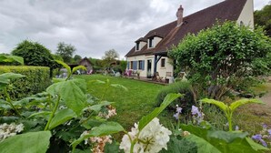 Ein traditionelles Haus mit einem gepflegten Garten und blauem Himmel.