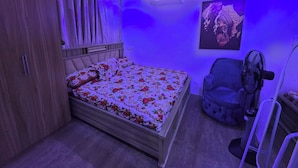 Ein Schlafzimmer mit einem Bett, einem Kleiderschrank, einem Sessel und einer Wand-Klimaanlage.