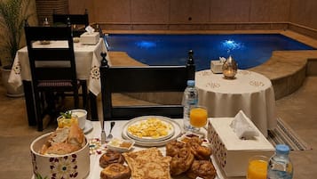 A breakfast setup with a pool in the background.