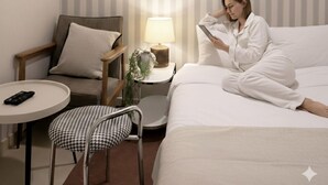 A hotel room with a bed, a chair, a small table, and a lamp. - Yellow stay (Bucheon)
