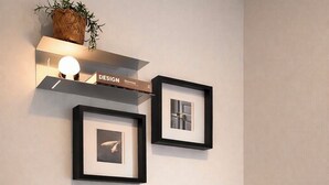 A corner of a room with a wooden chair, a round table, a framed picture, a shelf with a plant, and a wall-mounted light. - Yellow stay (Bucheon)