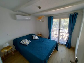 A bedroom with a bed, a small table with a lamp, and a window with curtains. - DIRECT BEACH ACCESS HOUSE WITH TERRACE (Poggio-Mezzana)
