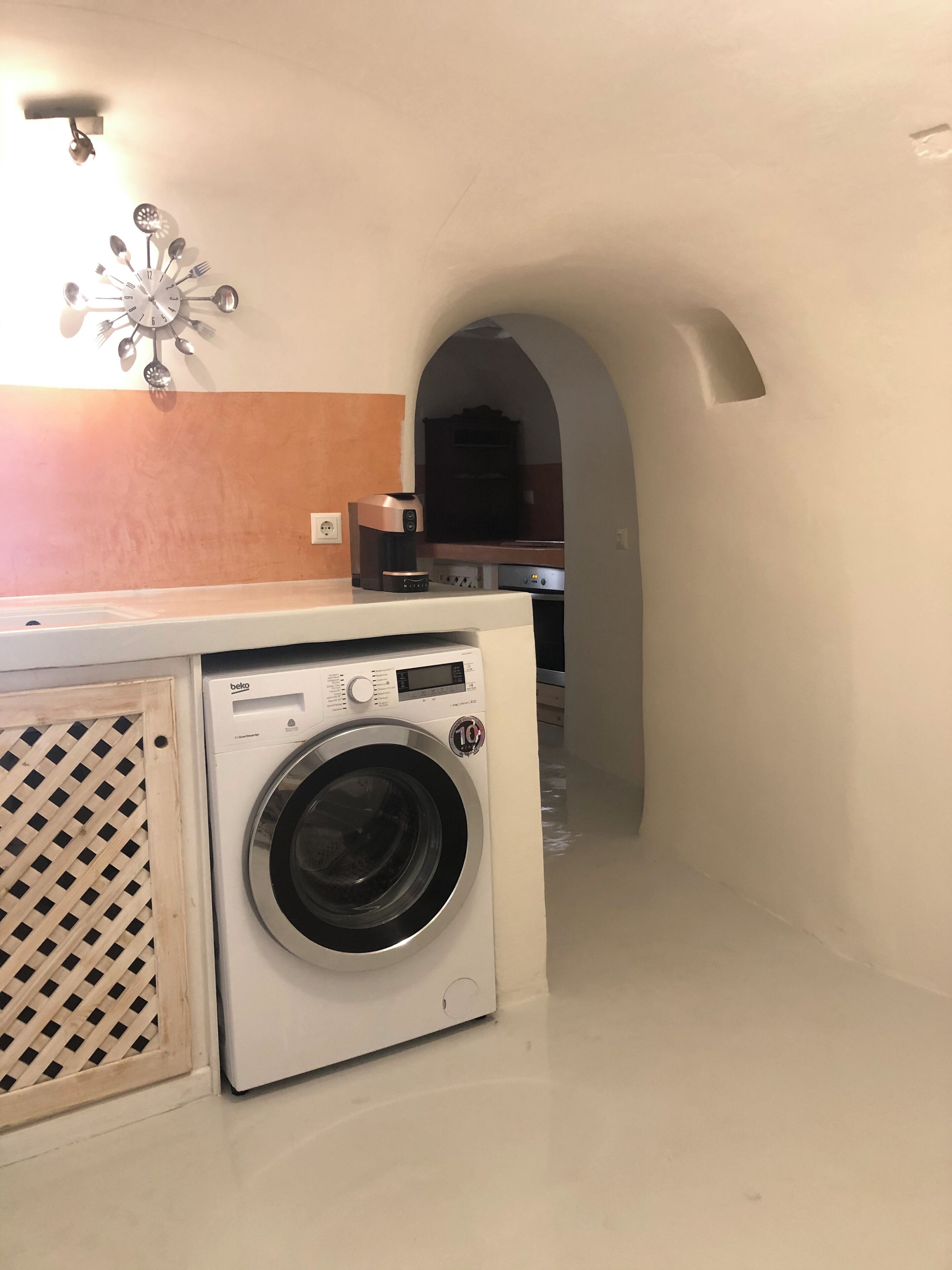 Eine kleine Küche mit Waschmaschine, Spüle und Mikrowelle.