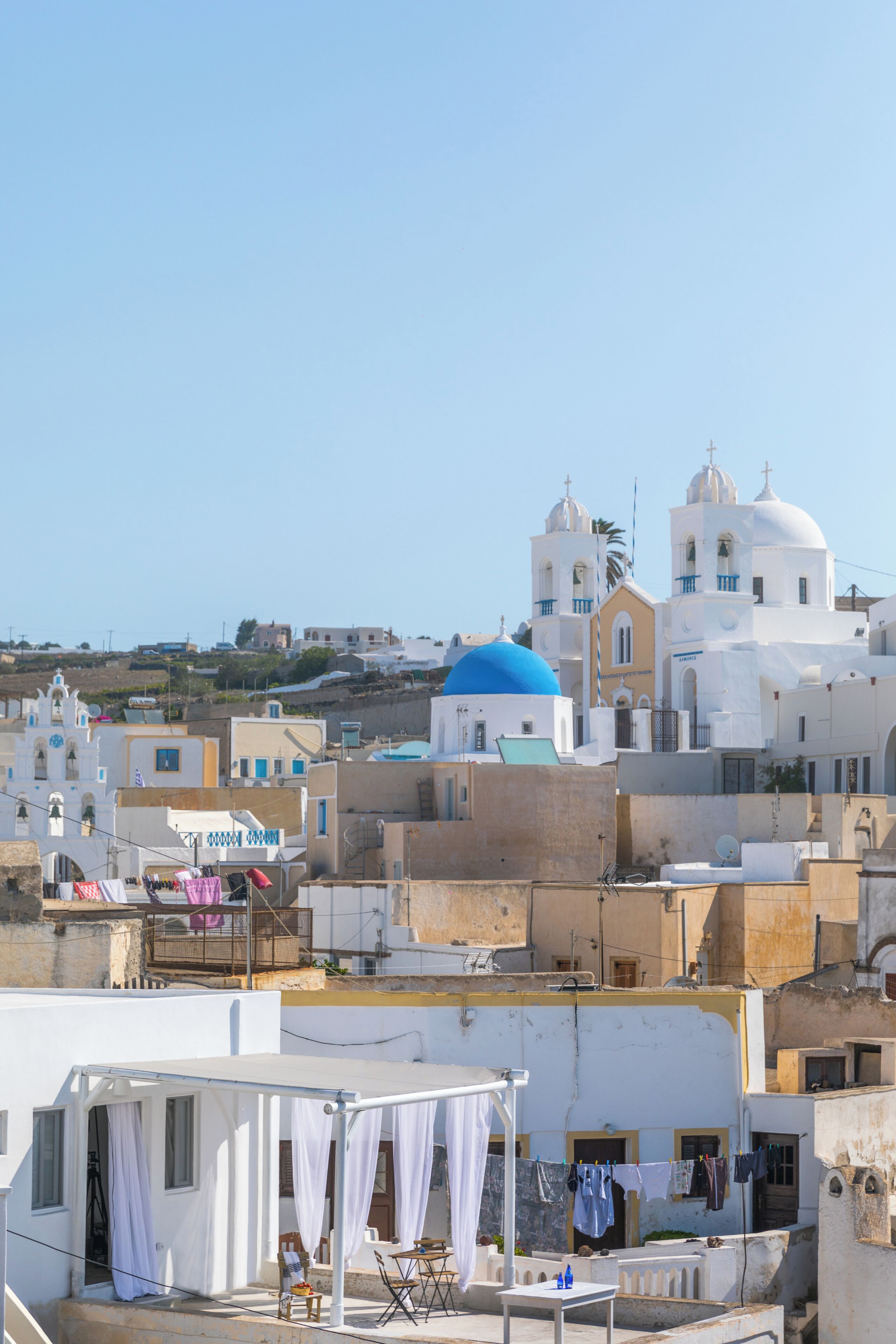 Un edifici blanc amb una cúpula blava i una torre campanar, envoltat d'altres edificis.