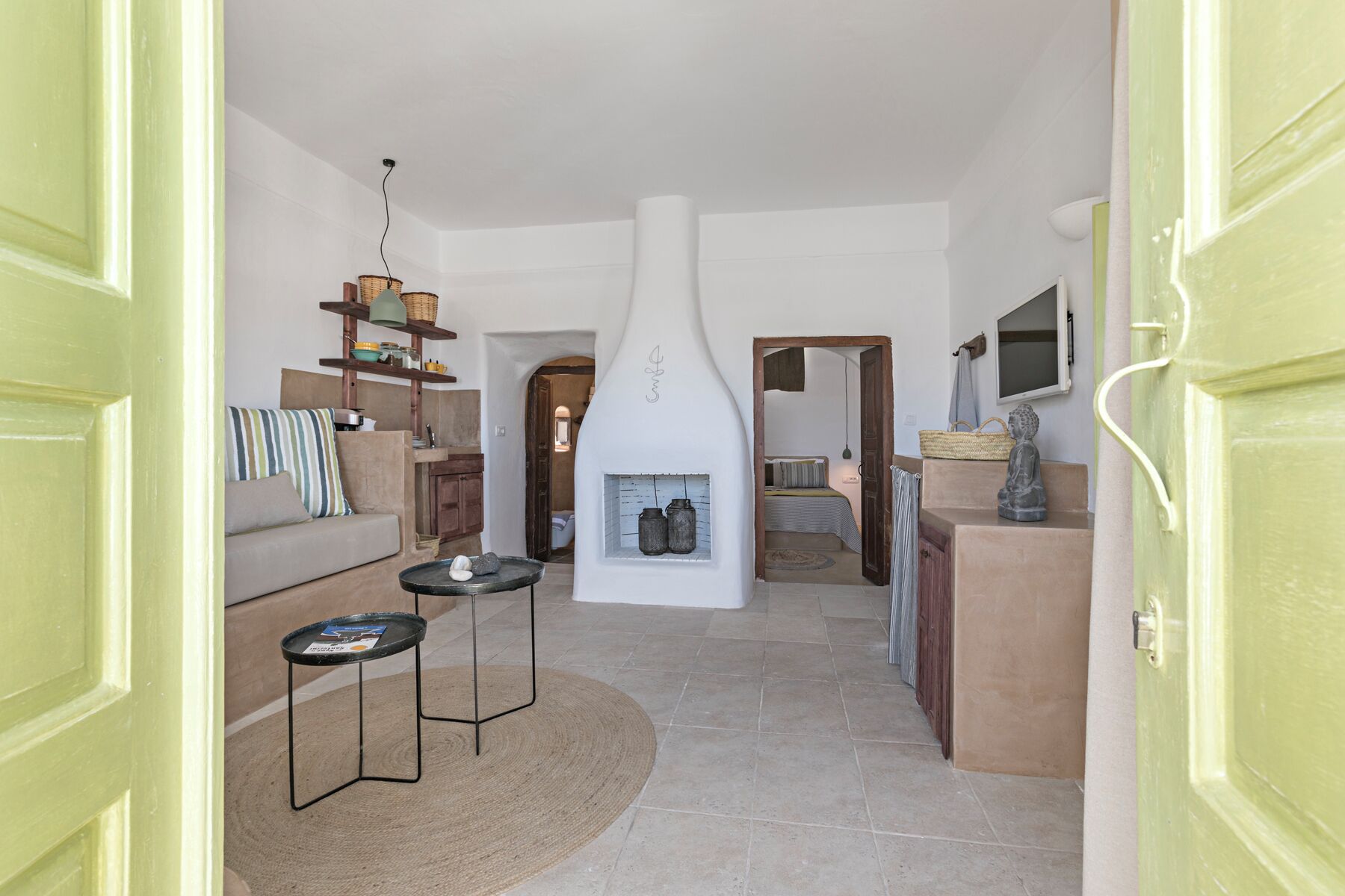 A spacious living area with a fireplace, a sofa, a coffee table, and a dining area with a TV.