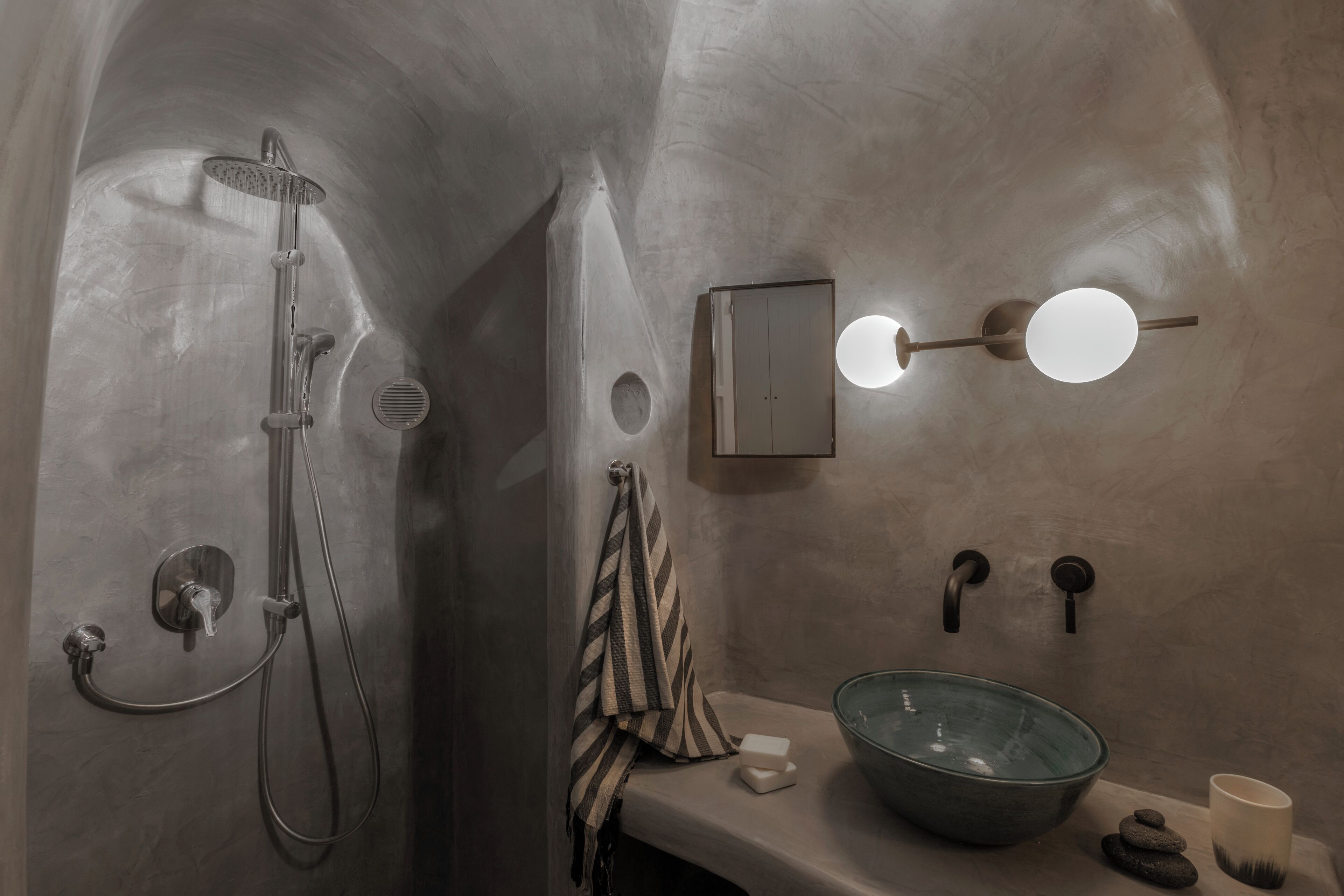 Un baño con ducha, lavabo, toalla y espejo.
