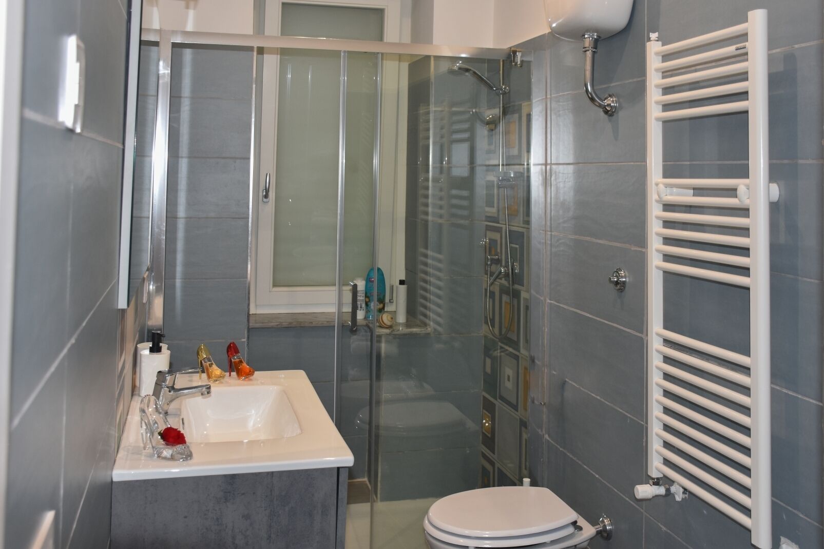 Ein Badezimmer mit einer Duschkabine, einem weißen Waschbecken und einer Toilette.