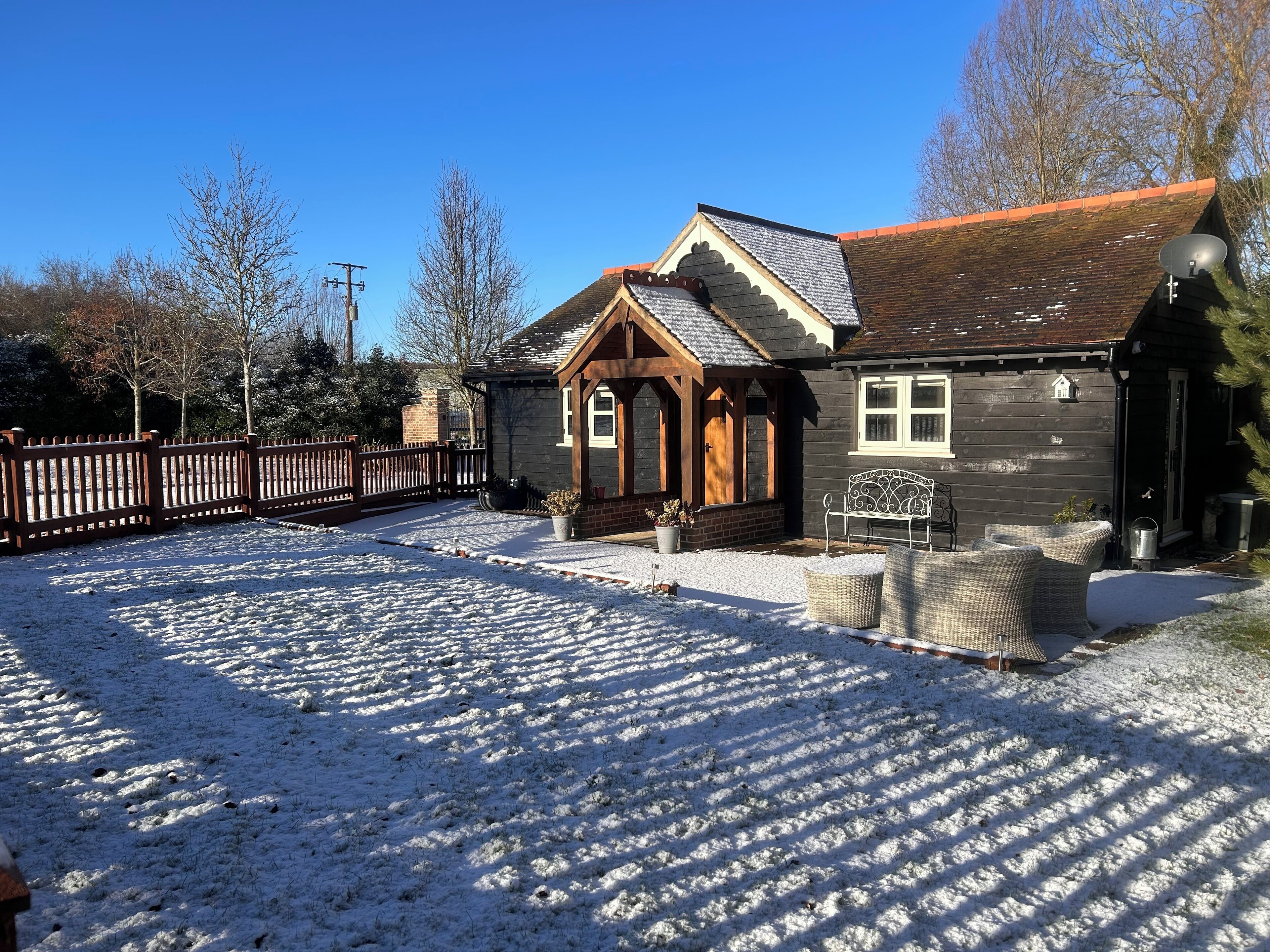 A wooden house with a sloped roof and a porch.