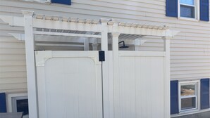 A white wooden gate with a pergola structure above it. - Experience coastal charm at Sand Dollar, a spacious 4-bedroom retreat in Ferry Beach, Saco, ME. (Saco)