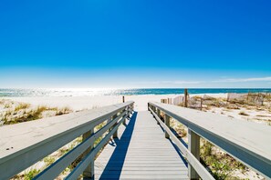 A wooden boardwalk leading to a beach with clear skies. - Dog Friendly Beachfront Paradise East Corner Unit (Orange Beach)