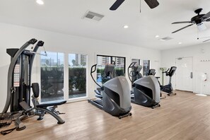 A gym with treadmills, a weight machine, and a ceiling fan. - Dog Friendly Beachfront Paradise East Corner Unit (Orange Beach)