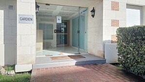 Une entrée d’immeuble avec une pancarte indiquant « GARDien ».