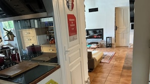 Eine Küche mit Herd, Töpfen und einem Schild, das auf eine Tourismus-Unterkunft hinweist.