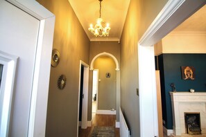A hallway with a chandelier, a fireplace, and a Buddha statue. - Large Bungalow - 3 Beds 2 Baths - Very Large Enclosed Garden - Dogs Stay Free (Birmingham)