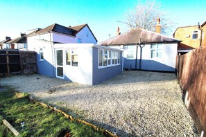 A residential property with a gravel driveway, a small garden, and a detached garage. - Large Bungalow - 3 Beds 2 Baths - Very Large Enclosed Garden - Dogs Stay Free (Birmingham)