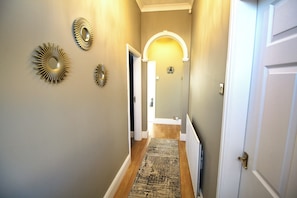 A hallway with a patterned rug, decorative wall mirrors, and a white door. - Large Bungalow - 3 Beds 2 Baths - Very Large Enclosed Garden - Dogs Stay Free (Birmingham)