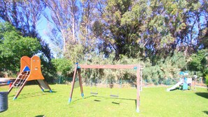 A playground with swings and a climbing structure. - Beachfront Penthouse With Pool Access (Marbella)