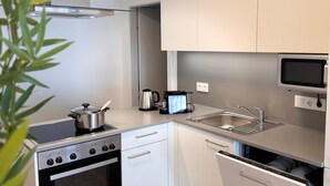 Een moderne keuken met roestvrijstalen apparatuur, witte kastjes en een ingebouwde oven.