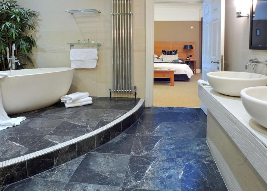 Junior suite | Badkamer | Een aparte badkuip en douche, een haardroger, handdoeken, zeep