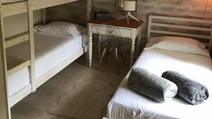 Un dormitorio con literas, un escritorio con lámpara y una mesita de noche.