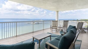 Ein Balkon mit Meerblick, einer Couch und zwei Stühlen.