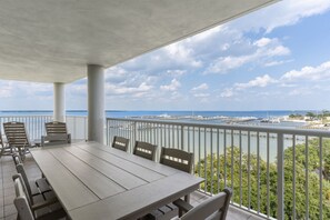 Un espace extérieur abrité, aménagé avec des sièges, et offrant une vue sur la mer et le port de plaisance.
