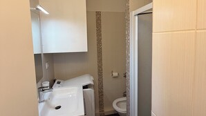 Un bagno piccolo con lavandino, specchio e WC bianchi.