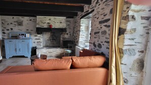 Una sala de estar acogedora con un sofá, un aparador azul y una chimenea.