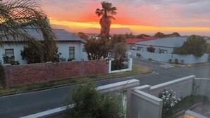 Ein Wohngebiet mit Häusern, einer Straße und einem Sonnenuntergang.