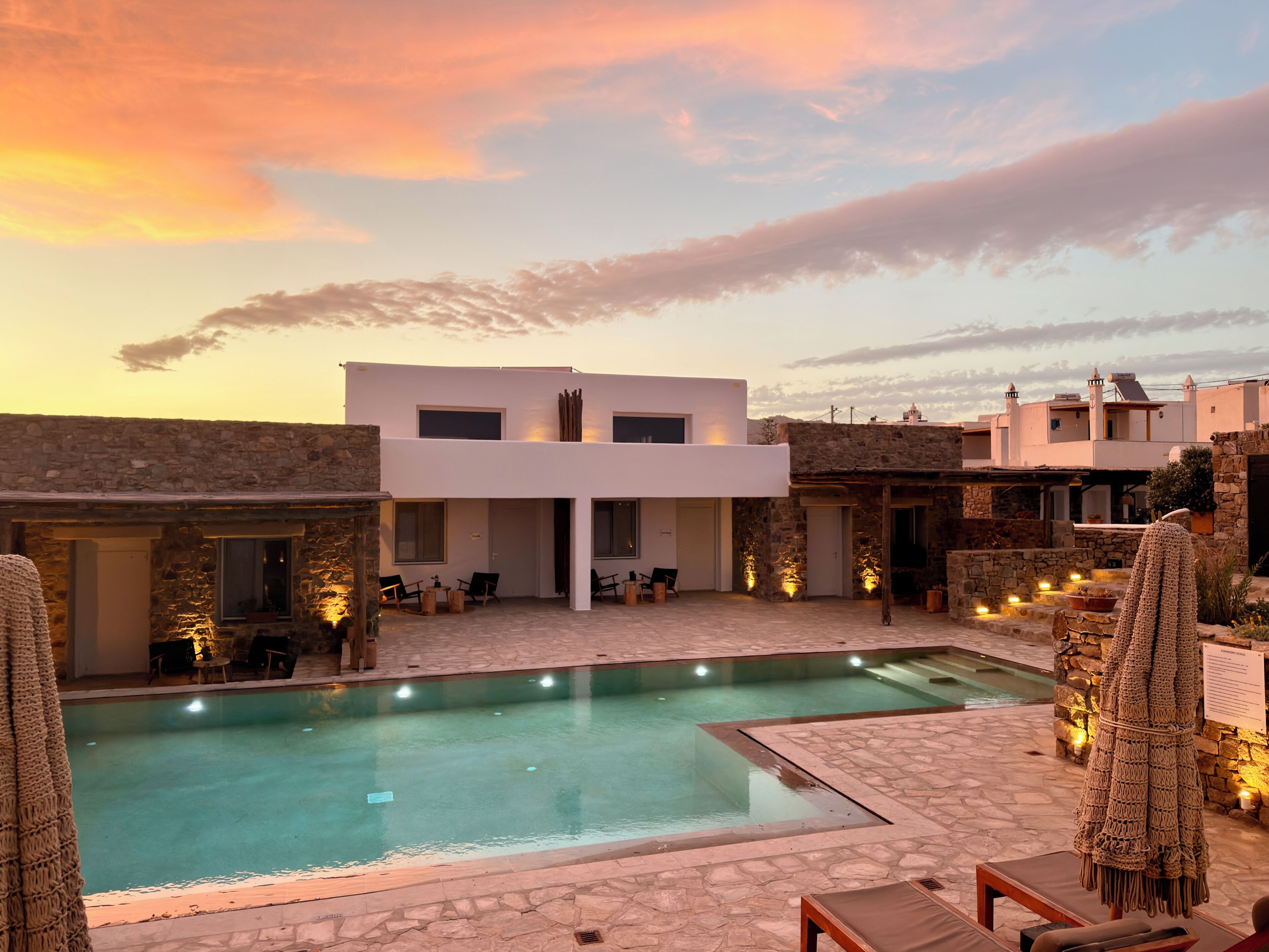 A modern pool area with a clear pool, stone flooring, and outdoor seating.
