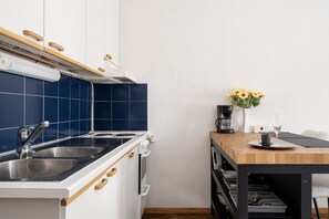 A kitchen with a sink, stove, and wooden cabinets. - Prime Location City Center Studio - Free Wi-Fi (Helsinki)
