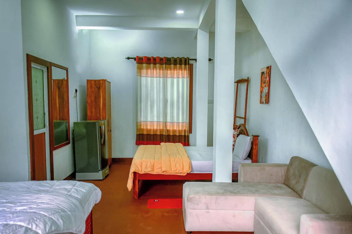 Ein Schlafzimmer mit Bett, Schlafsofa, Kleiderschrank und Spiegel.