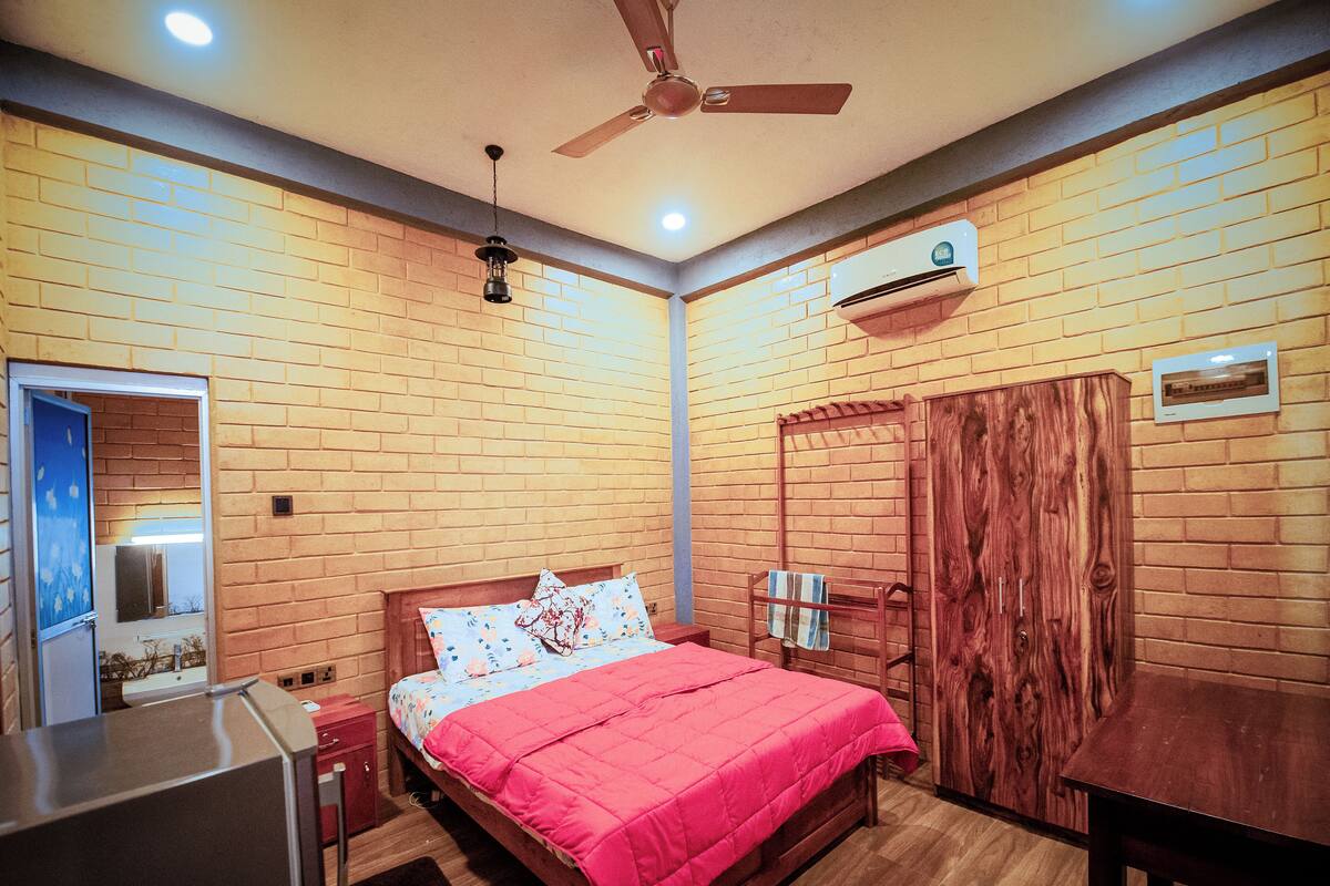 Ein Schlafzimmer mit einem hölzernen Bett, Deckenventilator, Klimaanlage und einem Holzschrank.