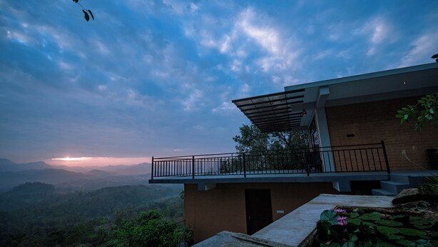 A modern building with a balcony overlooking a mountainous landscape. - Rocksana Fortress Yoga & Retreat (Mawanella)
