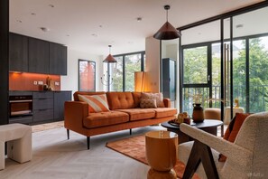 A modern living room with a sofa, coffee table, and pendant lights. - The Ironworks (Dublin)