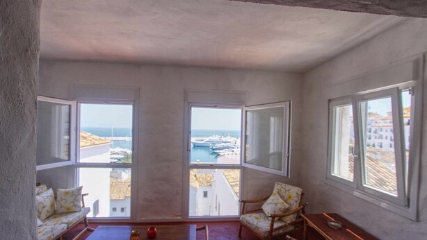 A balcony with a view of the sea and boats, furnished with a sofa, chairs, and a table. - Puerto Banus Apartment for 8 (Marbella)