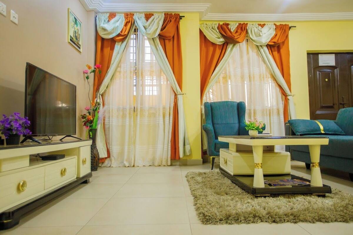 A living room with a TV, sofa, and a coffee table.