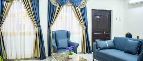 Una sala de estar con sofá, sillón y mesa de centro.