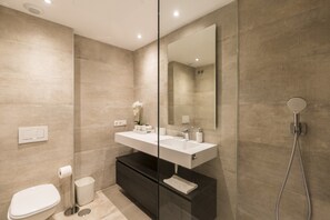 A modern bathroom with a glass-enclosed shower, a white sink, and a dark vanity. - Elegant Lagoon Retreat for 4 (Casares)