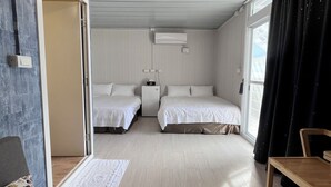 A hotel room with two beds, a desk, a chair, a window with curtains, and an air conditioning unit. - Overseas Ryukyu studies Homestay (Liuqiu)