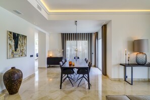 A modern dining area with a long table, chairs, a vase, and a lamp. - Luxury Family Villa for in Marbella (Marbella)