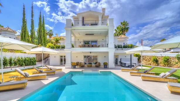 A large, multi-story building with a swimming pool in the foreground. - Luxury Family Villa for in Marbella (Marbella)