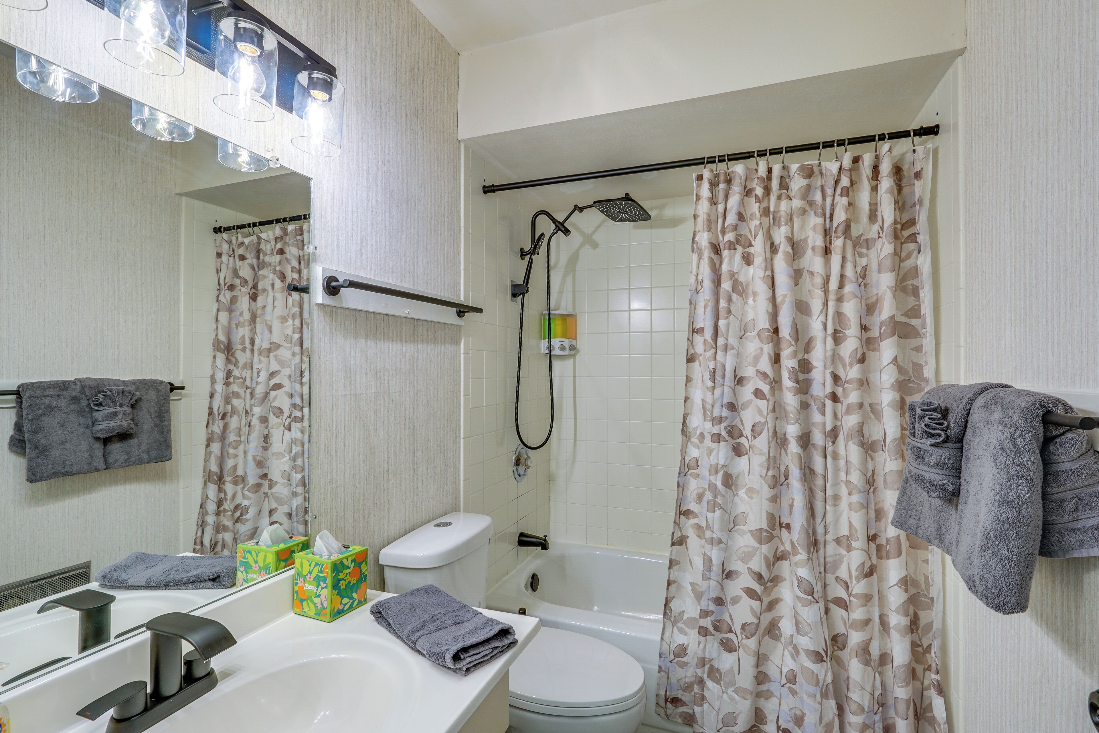 A bathroom with a bathtub, toilet, sink, and a shower curtain.