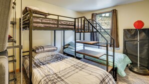Habitación con literas, una escalera, una ventana con cortinas y un globo rojo.