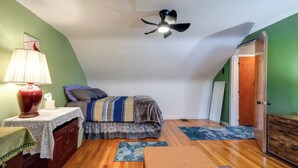 A bedroom with a bed, a nightstand, a lamp, a ceiling fan, and a door. - 3 Mi to UD & Kettering Health! Suburban Stay (Dayton)