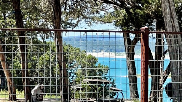 Ein eingezäunter Bereich mit Blick auf Strand und Bäume.