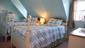 A bedroom with two beds, a dresser, a nightstand, a lamp, and a window with curtains. - West Ocean City Vacation House Rental in Quiet Residential Neighborhood (Ocean City)