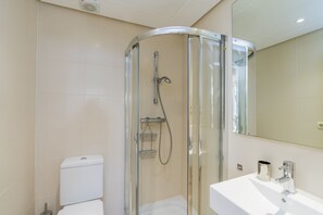 A modern bathroom with a glass-enclosed shower, a white sink, and a large mirror. - Lagoon Apartment Retreat for 4 (Casares)