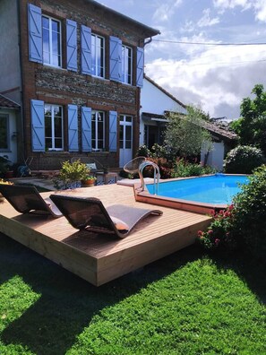 A two-story house with a swimming pool, wooden deck, and outdoor seating area. - A Toulouse woman of character (Lavernose-Lacasse)