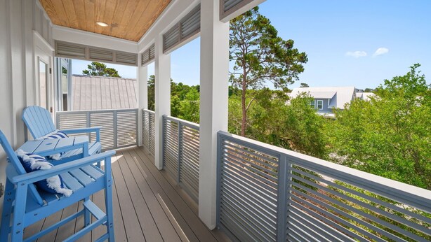 A covered outdoor area with a wooden ceiling, white walls, and a view of greenery and buildings. - New! 5 minutes from Rosemary Beach! Bikes, Beach Gear, Game & Bunk Room, 8 Beds (Inlet beach)